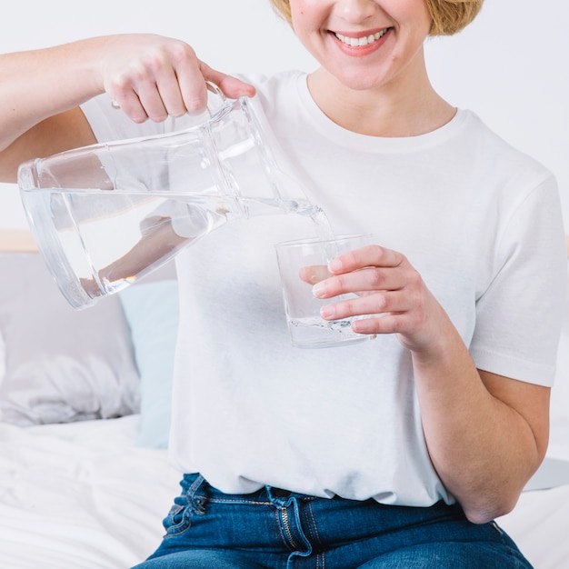 Foto gratuita mujer de la cosecha en la cama que vierte el agua