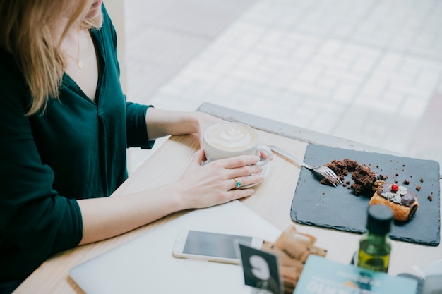 Foto gratuita la mujer de la cosecha gana el café cerca de la ventana del café