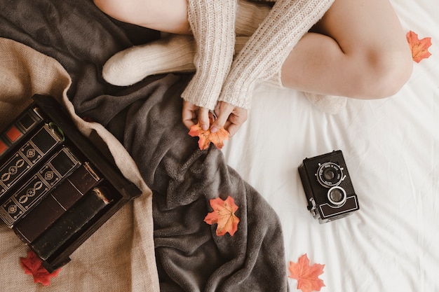 Foto gratuita mujer de la cosecha con la hoja cerca de la cámara y libros