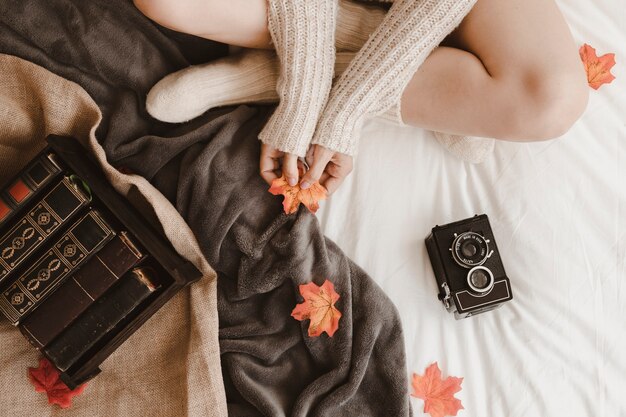 Mujer de la cosecha con la hoja cerca de la cámara y libros