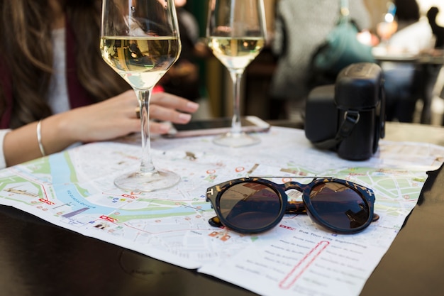 Mujer de cosecha con mapa sentado en la mesa