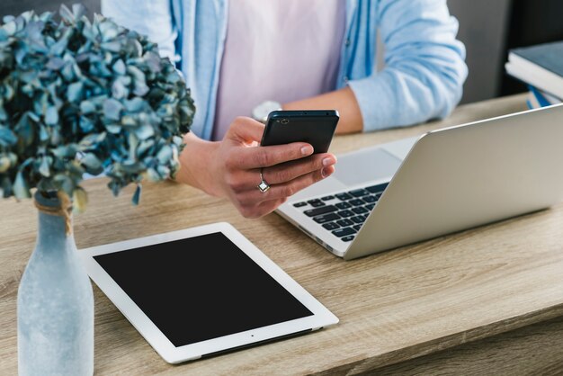 Mujer cosecha navegación smartphone en la oficina