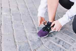 Foto gratuita mujer de la cosecha que ata cordones en las zapatillas de deporte