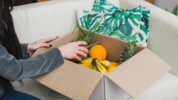 Foto gratuita mujer de la cosecha que controla el paquete de la fruta