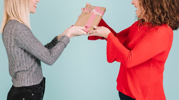 Mujer de la cosecha que da el regalo a la mamá