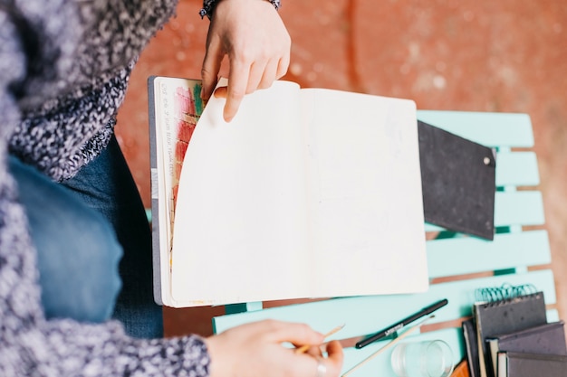 Mujer de la cosecha que da vuelta a las páginas del cuaderno de bocetos