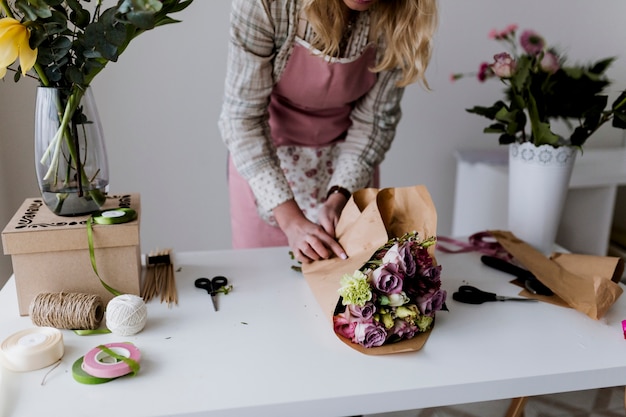 Mujer de la cosecha que envuelve las flores al papel