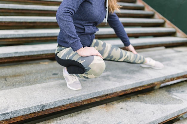 Mujer de la cosecha que estira las piernas en las escaleras