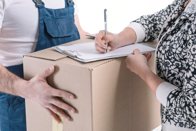 Mujer de la cosecha que firma para el paquete