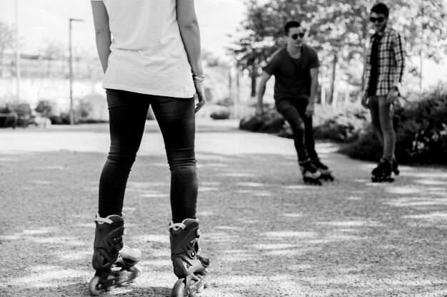 Mujer de la cosecha que mira a hombres del patinaje sobre ruedas