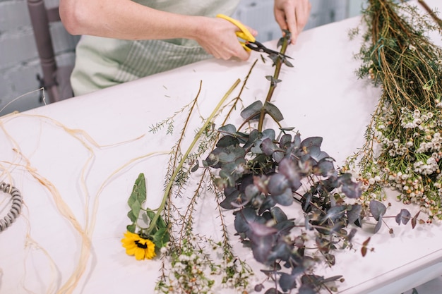 Mujer de la cosecha que prepara las flores para el ramo