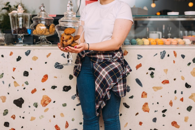 Foto gratuita mujer de la cosecha que sostiene la galleta palatable