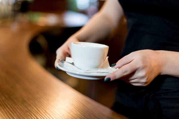 Mujer de la cosecha que sostiene la taza de bebida caliente