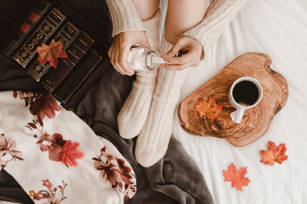 Mujer de la cosecha que toma el azúcar para el té en cama