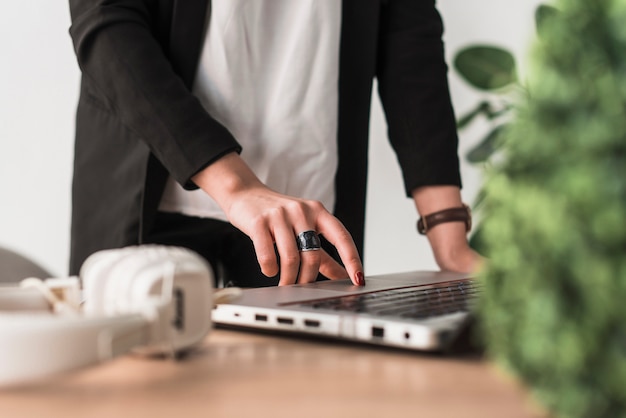 Mujer de la cosecha que usa la computadora portátil en oficina