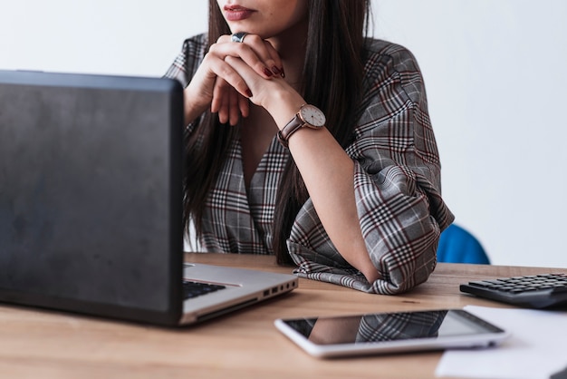 Foto gratuita mujer de la cosecha que usa la computadora portátil y el pensamiento