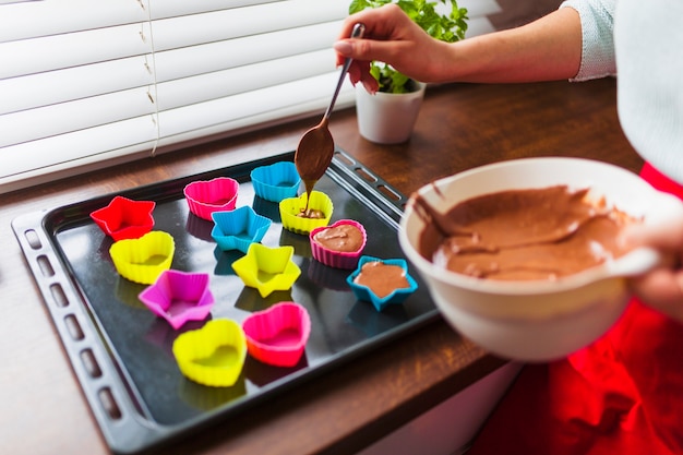 Foto gratuita mujer de la cosecha que vierte la mantequilla en tazas