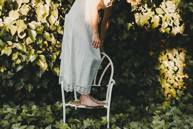 Mujer de la cosecha en la silla en el jardín