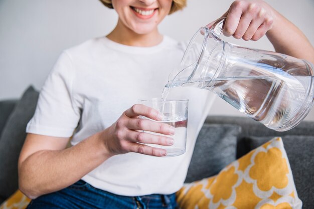 Mujer de cosecha verter agua