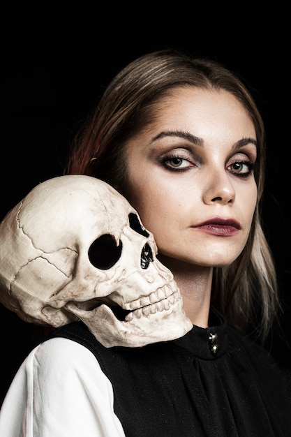 Mujer con cráneo humano en el hombro