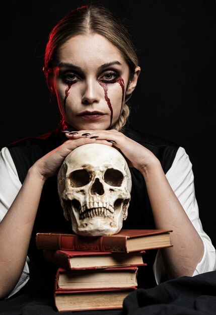 Mujer con cráneo humano y libros