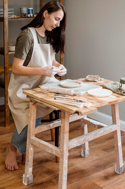 Mujer creativa haciendo una olla de barro en su taller