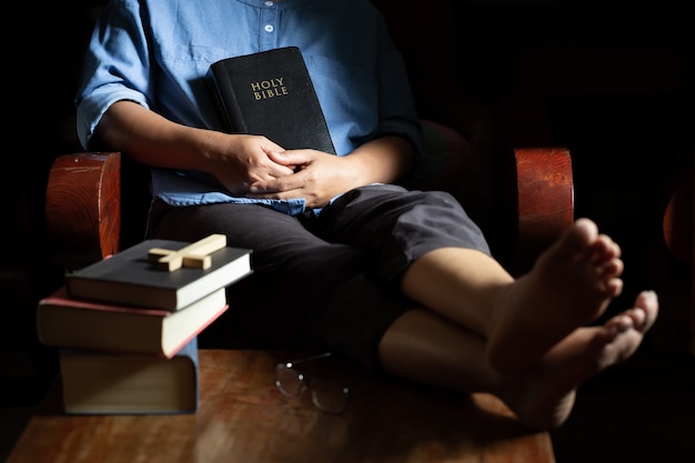 Una mujer cristiana sentada en una silla de madera.