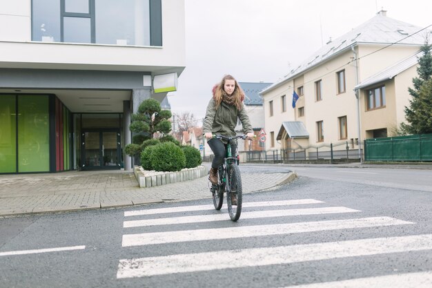 Mujer cruzando la calle en bicicleta