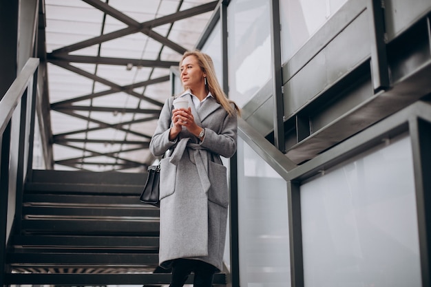 Mujer cruzando el puente y tomando café