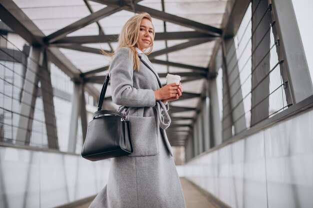 Mujer cruzando el puente y tomando café