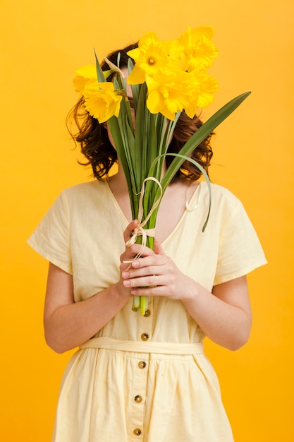 Mujer cubre la cara con flores