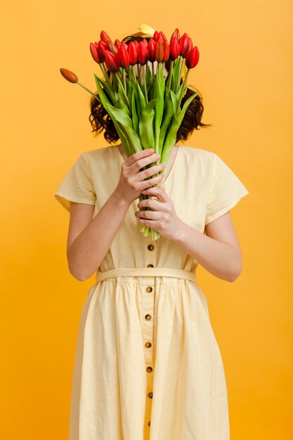 Mujer cubre la cara con flores