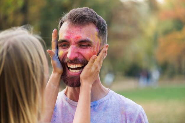 Mujer cubriendo la cara de un hombre con pintura