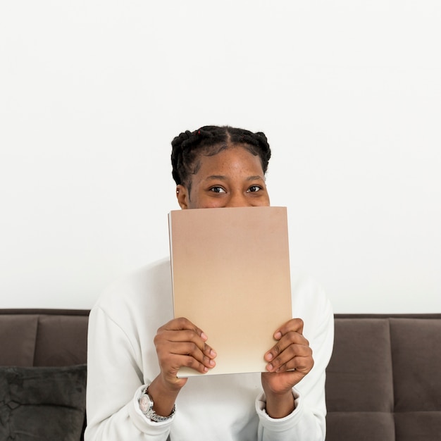 Mujer cubriéndose la cara con el libro