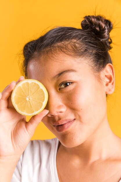 Mujer cubriéndose la cara con limón