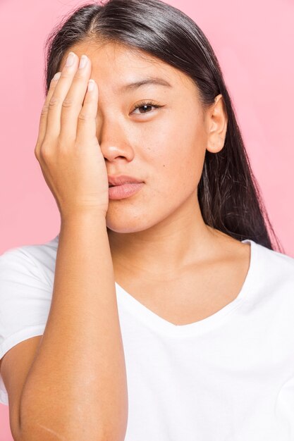 Mujer cubriéndose la cara con una mano