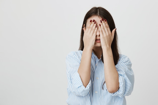 mujer cubrir la cara con las manos