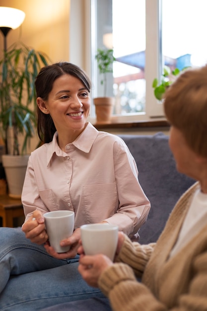 Foto gratuita mujer cuidadora en la casa de su cliente cuidando a una persona mayor