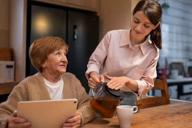 Foto gratuita mujer cuidadora en la casa de su cliente cuidando a una persona mayor