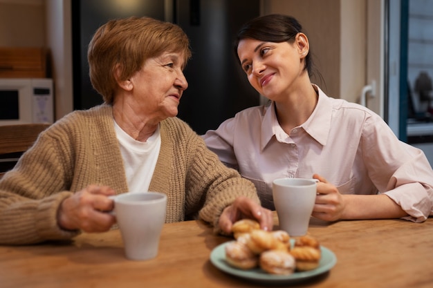 Mujer cuidadora en la casa de su cliente cuidando a una persona mayor