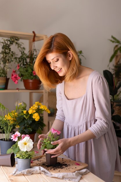 Mujer cuidando de plano medio de la planta