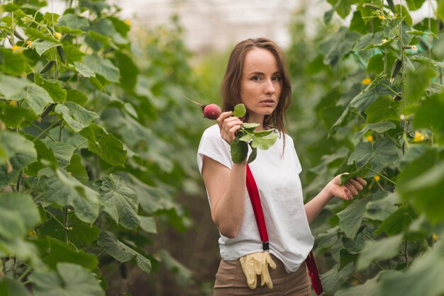 Mujer cuidando plantas en un invernadero