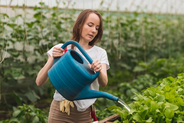 Mujer cuidando plantas en un invernadero