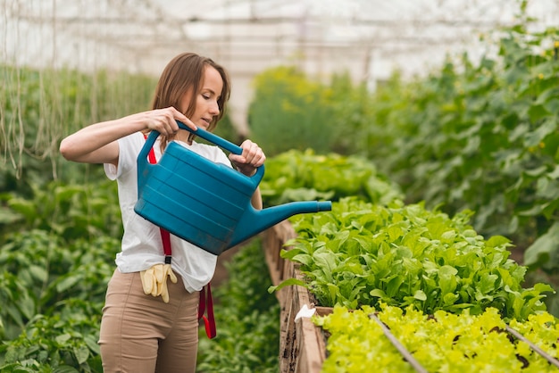 Mujer cuidando plantas en un invernadero