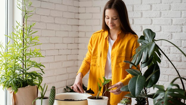 Mujer cuidando sus plantas en el jardín de su casa