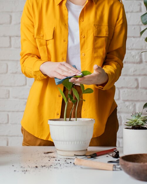 Mujer cuidando sus plantas en el jardín de su casa