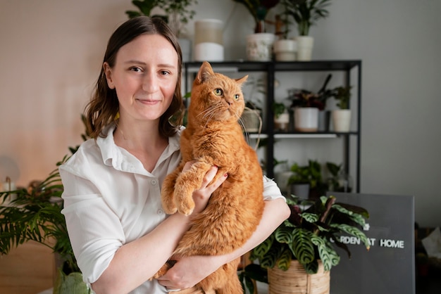 Mujer cultivando plantas en casa con gato