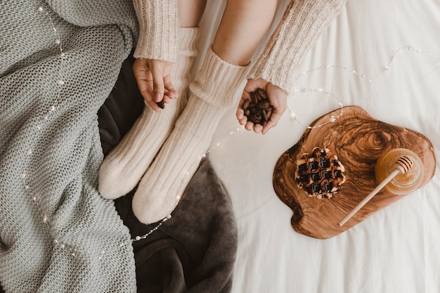 Mujer de cultivo con almendras cerca de waffle y miel