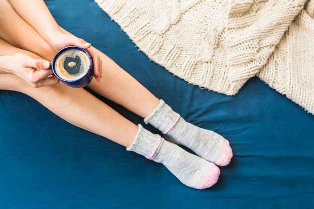 Mujer de cultivo en la cama con café