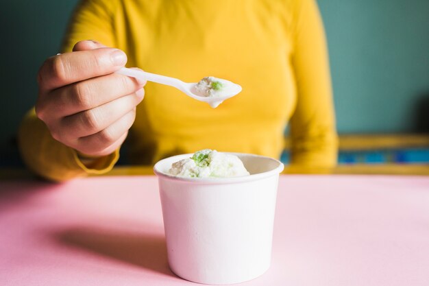 Mujer de cultivo comiendo helado